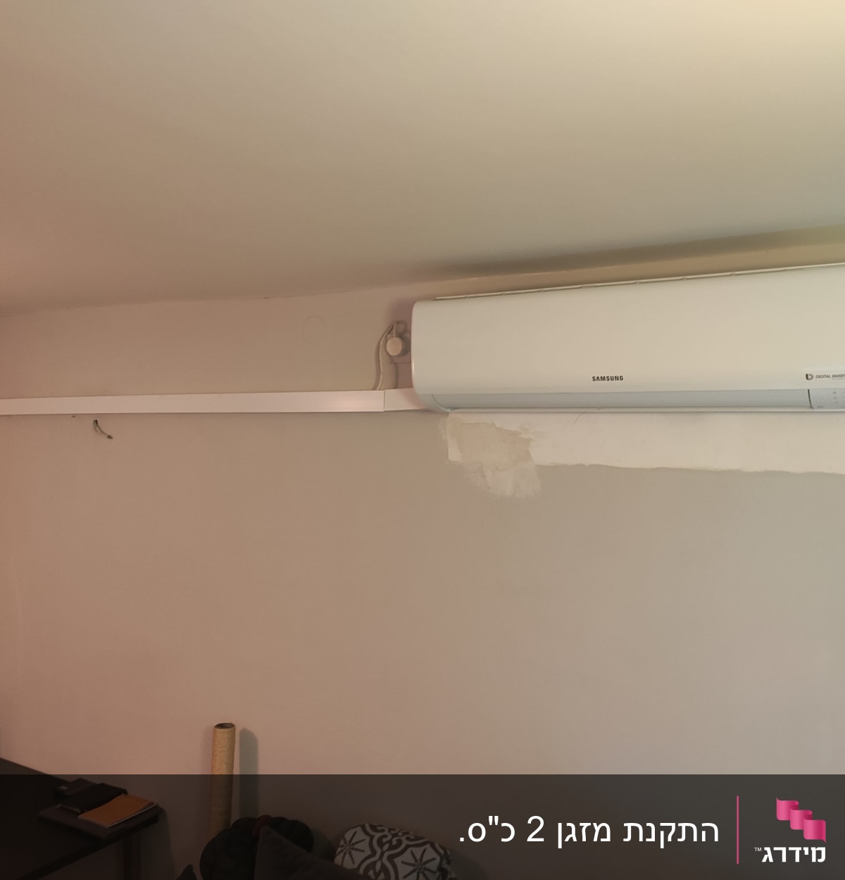 מזגן מותקן על קיר עם צינור חיצוני